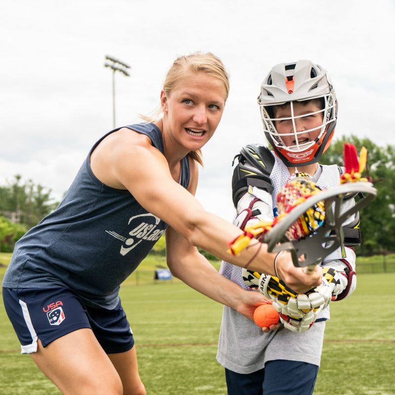 Coach Ally Carey teaching boy lacrosse skills
