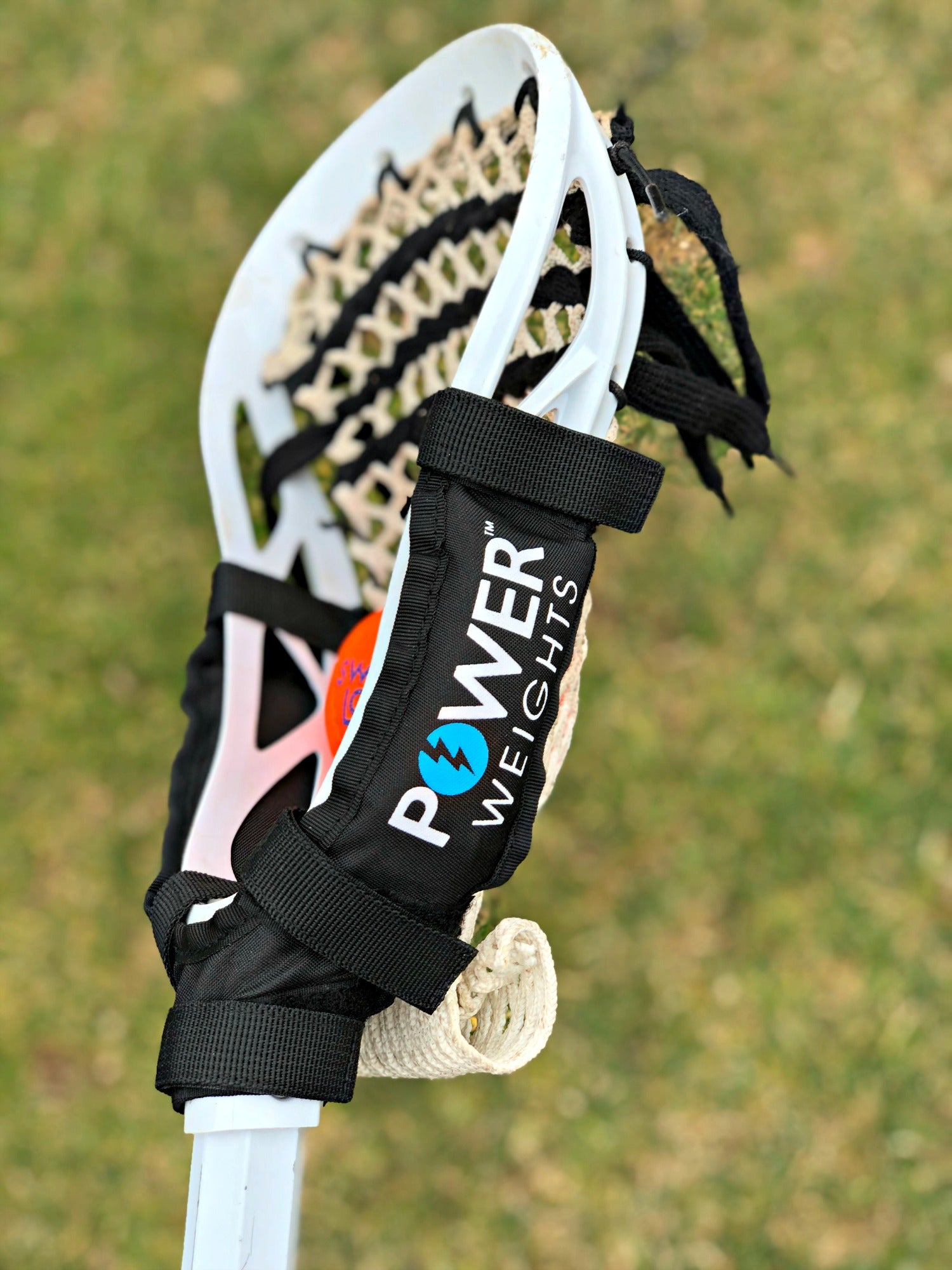 Swax Lax Power Weights shown on boy's lacrosse stick - side view