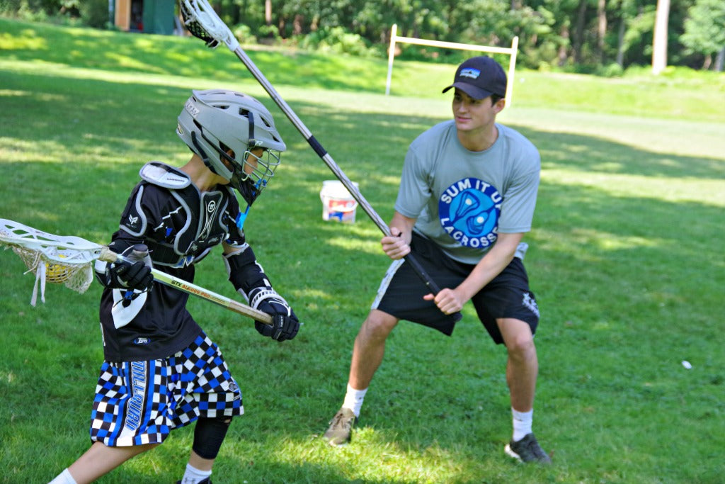 Lacrosse coach and player practicing boys lacrosse drill