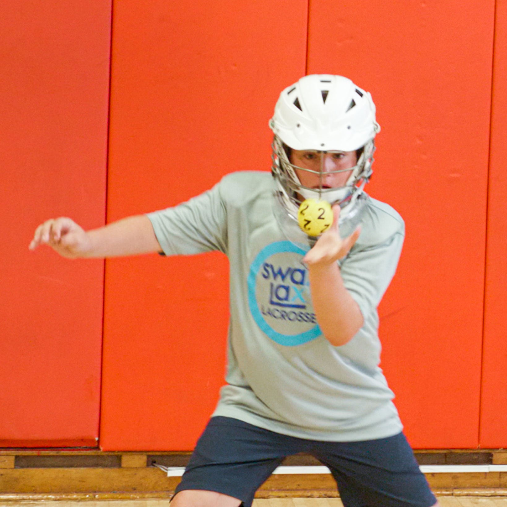 Lacrosse goalie with laser focus catching a Swax Lax goalie ball